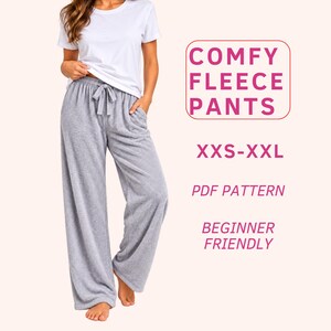May include: A white short-sleeved t-shirt and grey fleece pants with a drawstring waist. Text on the right reads: COMFY FLEECE PANTS, XXS-XXL, PDF PATTERN, BEGINNER FRIENDLY. The pants feature a wide-leg cut and a soft, textured fabric.