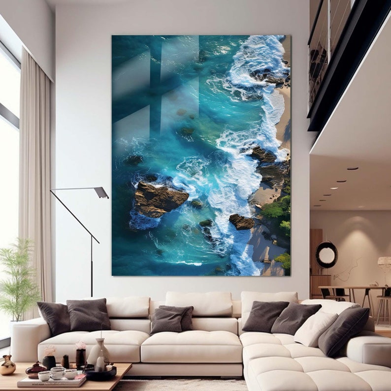 May include: An aerial view of a rocky coastline with turquoise blue water crashing against the shore. The waves are white and foamy, and the rocks are brown and gray.