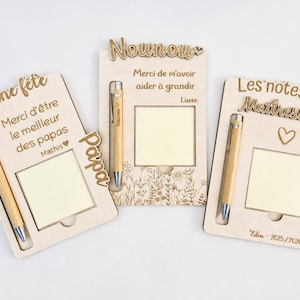 Peut inclure: Trois supports mémo rectangulaires en bois clair avec stylos en bambou intégrés et blocs de notes adhésives carrés. Chaque support présente des textes gravés au laser en français, incluant Bonne fête, Nounou, et Les notes de Maîtresse.