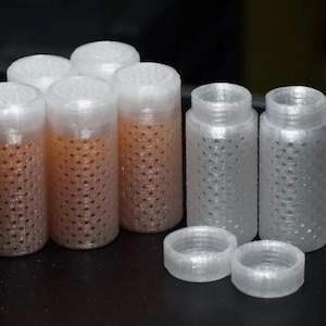 May include: A set of six white plastic containers with a textured surface and a small hole pattern. The containers are arranged in two rows of three. There are also two additional white plastic lids.