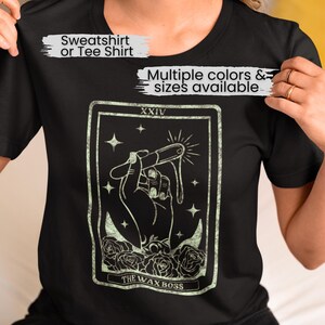 May include: Black t-shirt with a tarot card design featuring a hand holding a dripping candle. The card reads "XXIV THE WAX BOSS".