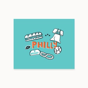 Può includere: Grafica turchese con icone di Filadelfia. Include un panino, la Liberty Bell, un pallone da basket, un pallone da football americano, un pretzel e la parola "PHILLY" in arancione. È incluso anche il cartello di Broad St.