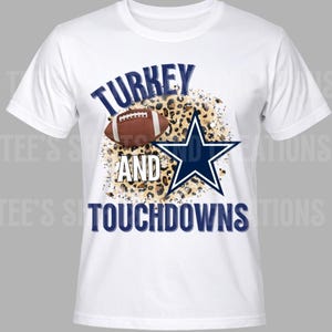 May include: White t-shirt with the navy blue text "TURKEY AND TOUCHDOWNS", a football, and a star logo. The design incorporates a leopard print pattern in the background.