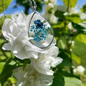 necklace with resin pendant and blue flowers