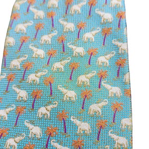 May include: A light blue tie with a repeating pattern of white elephants and orange palm trees. The tie has a textured weave and a classic shape, suitable for formal or semi-formal occasions.