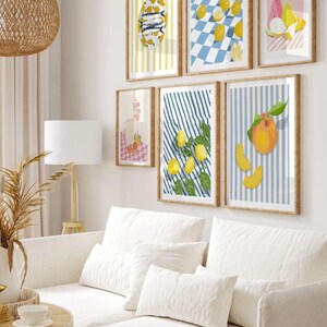 May include: A set of six framed prints featuring various still life arrangements of fruit, including lemons, peaches, and watermelon. The prints are all in a similar style, with a white background and colorful stripes. The frames are all wooden and have a natural finish.