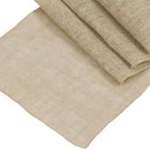 May include: A natural burlap table runner, ideal for adding a rustic touch to your dining table. The runner is a light beige colour and has a slightly textured surface.