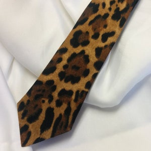 May include: A brown and black leopard print tie with a pointed end.
