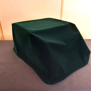 以下が含まれることがあります： 家具または機器用の濃い緑色の布製カバー