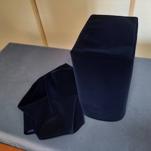 以下が含まれることがあります： 柔らかくベルベットのような生地で作られた、濃い青色のスピーカーカバー2つ。カバーは長方形で、滑らかで均一な質感です。