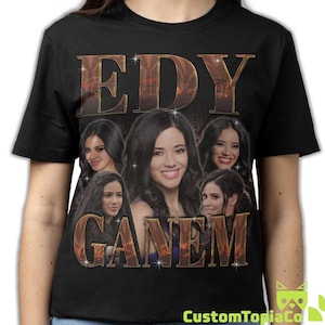May include: A black short-sleeve t-shirt featuring a collage of five photographic portraits of the same individual with long dark hair. The text EDY is printed in large metallic gold letters above the portraits and GANEM below in the same style.
