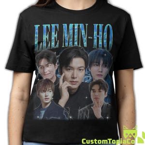 May include: Black t-shirt featuring a graphic of Lee Min-Ho with his name in a blue, stylized font. The design includes multiple images of the actor with a vintage aesthetic. The shirt is a crew neck style.