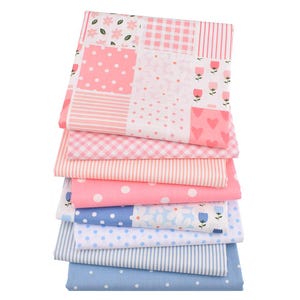 May include: A stack of patterned fabric squares in pink and blue. Designs include polka dots, stripes, gingham, floral, and heart patterns. The fabric is likely cotton or a similar material, suitable for quilting or crafting projects.