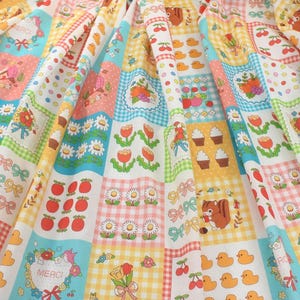 May include: A colorful patchwork fabric featuring a variety of patterns. The design includes squares with cherries, cupcakes, ducks, flowers, squirrels, and bows. The fabric has a mix of gingham, polka dots, and floral prints in pastel colors.