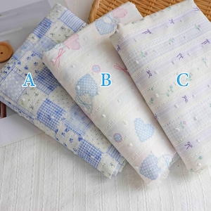 May include: Three patterned fabrics are displayed. Fabric A features a blue and white check and floral design. Fabric B is white with blue heart shapes and pink bows. Fabric C is white with purple stripes and bow accents.