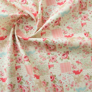 May include: A patchwork fabric with a floral pattern in shades of pink, white, and blue. The fabric features a repeating pattern of squares with different floral designs.