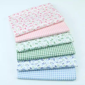 Könnte beinhalten: Ein Stapel aus sechs Stoffquadraten in verschiedenen Mustern. Das oberste Quadrat ist weiß mit einem rosa Blumendruck, das zweite ist rosa-weißes Gingham, das dritte ist weiß mit einem grünen Blumendruck, das vierte ist grün-weißes Gingham, das fünfte ist weiß mit einem blauen Blumendruck und das unterste Quadrat ist blau-weißes Gingham.
