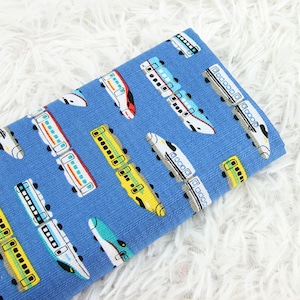 May include: Blue fabric with a repeating pattern of colorful trains. The trains are in various styles and sizes, including bullet trains and boxcars.