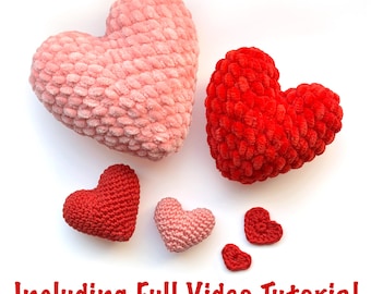 May include: Five crocheted hearts in various sizes, two large hearts in pink and red, three smaller hearts in red and pink.  The hearts are on a white background.  The text "Including Full Video Tutorial" is at the bottom of the image.