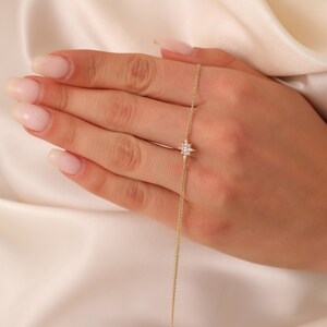 May include: A delicate gold chain necklace with a small, sparkling star pendant. The star is made of clear diamonds and has a pointed design.