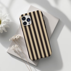 May include: A black and beige striped phone case with a camera lens cutout.