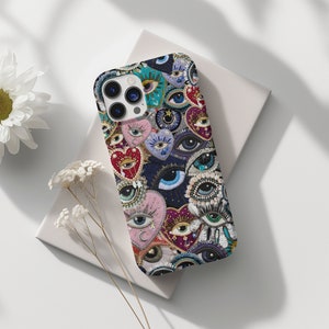 Könnte beinhalten: Eine farbenfrohe Handyhülle mit einem Muster aus Augen und Herzen. Die Hülle ist aus strapazierfähigem Material gefertigt und hat ein elegantes Design.