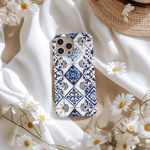 May include: A blue and white phone case with a geometric tile pattern. The case is designed for an iPhone with a camera lens cutout.