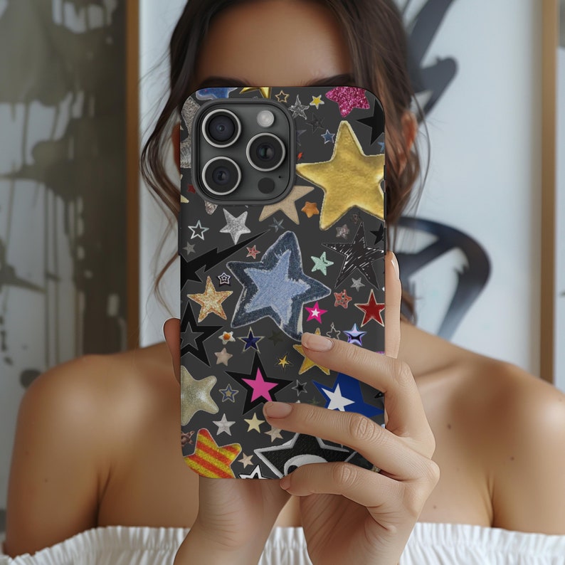 K&ouml;nnte beinhalten: Eine schwarze Handyh&uuml;lle mit einem bunten Sternenmuster. Die H&uuml;lle hat eine Vielzahl von Sternen in verschiedenen Farben, Gr&ouml;&szlig;en und Texturen. Die H&uuml;lle ist f&uuml;r ein iPhone konzipiert.