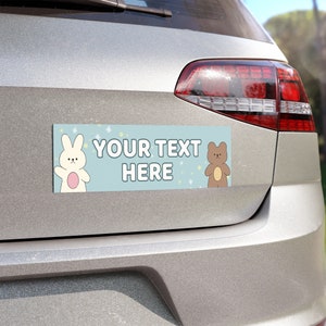 May include: A blue and white car bumper sticker with a white rabbit and a brown bear. The sticker says "YOUR TEXT HERE" in white text.