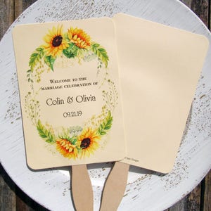 Sunflower wedding fans, personalized for the bride and groom adorned with a circle of sunflowers.  Printed on ivory cardstock with wooden handle hidden between front and back cardstock.  Wedding favor fans come fully assembled.