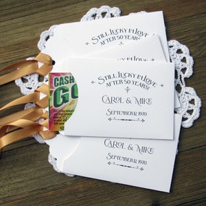 Our 50th wedding anniversary favors are personalized for the happy couple.  Printed on white cardstock with gold ribbon attached these will be a fun favor to give to guests.  Slide a lotto ticket in the open end and see who wins.