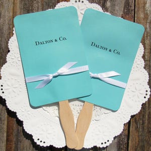 Aqua blue wedding fans personalized and assembled with ribbon which comes attached.  Accent your wedding with these elegant fans.
