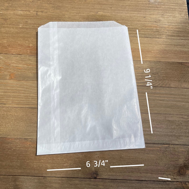 May include: White paper bag with a 6 3/4 inch by 9 1/4 inch size.