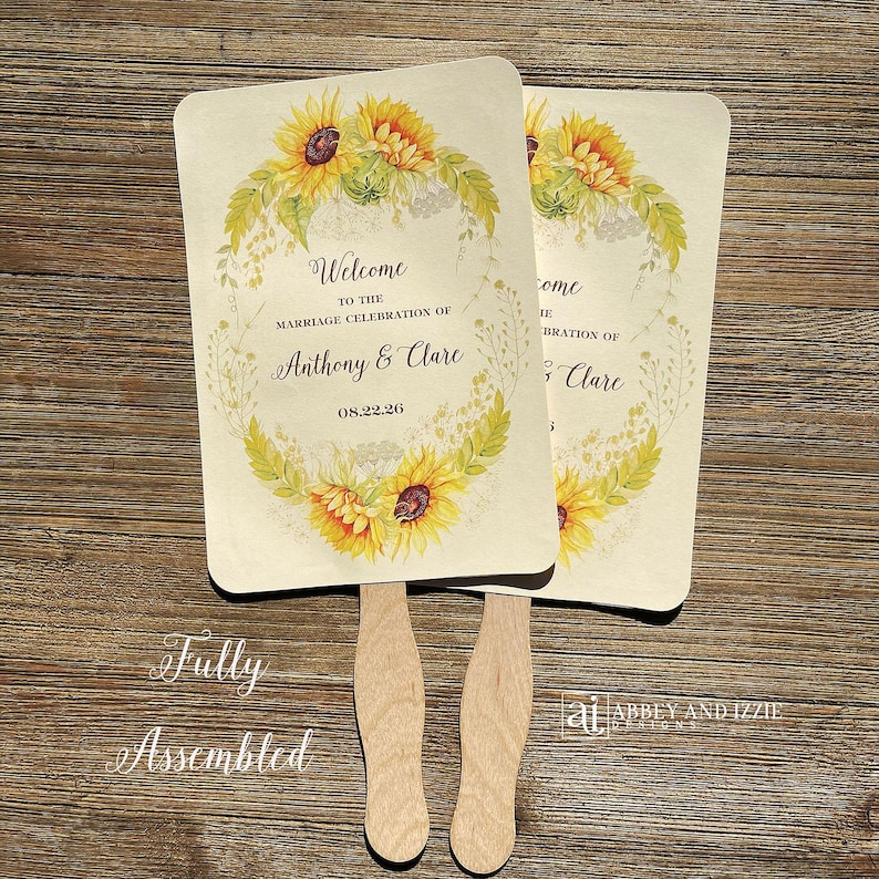 Sunflower wedding fans , personalized for the bride and groom and adorned with a ring of sunflowers.  Fans are printed on ivory cardstock, two sided so handle is hidden between.  Wedding fans ship fully assembled and ready for your big day.
