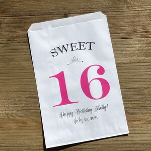 Op de afbeelding: Witte papieren traktatiezak met de woorden "SWEET" en een grote roze "16" op de voorkant. Daaronder staat de tekst "Happy Birthday Molly! July 10, 2021". De zak ligt op een houten oppervlak.