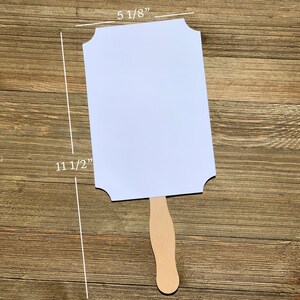May include: White blank sign with scalloped edges attached to a wooden handle. The sign measures 11 1/2 inches tall and 5 1/8 inches wide.