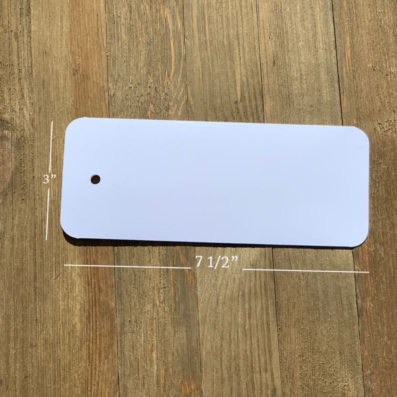 May include: A white rectangular sign with rounded corners and a hole in the top. The sign measures 7 1/2 inches by 3 inches.