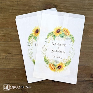 Sunflower wedding favor bags that are personalized for the bride and groom.  Adorned with a circle of sunflowers.  Perfect for cookies or a candy buffet.