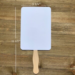May include: White blank hand fan with a wooden handle. The fan measures 5 1/4 inches wide and 11 1/2 inches tall.