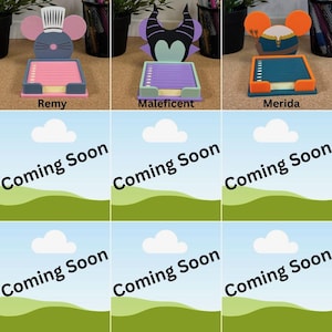 May include: Three character-themed sticky note holders with paper pads. The first features a grey mouse with a chef hat, the second a black and purple horned figure, and the third an orange-eared character with a blue and gold outfit.