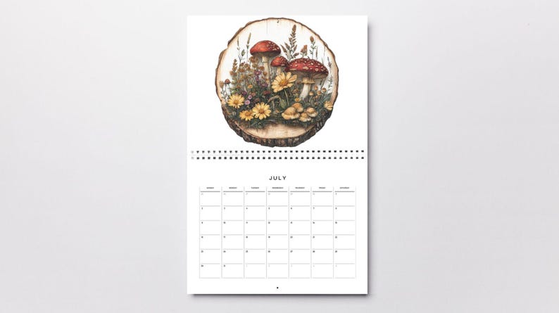 May include: A July calendar page with a wood slice illustration featuring red and white mushrooms, yellow flowers, and green leaves. The month of July is printed at the top of the calendar.