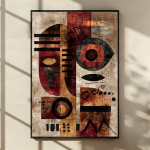 May include: Abstract art print in a black frame. The artwork features geometric shapes in shades of red, brown, and black against a beige background. The design includes circles, lines, and a textured appearance.