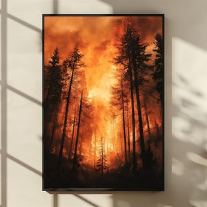 以下が含まれることがあります： 森林火災を描いた額装アートプリント。高く暗い木のシルエットが、強烈なオレンジ色の炎と煙を背景にしています。アートワークは黒い縁で額装されており、劇的なコントラストを生み出しています。