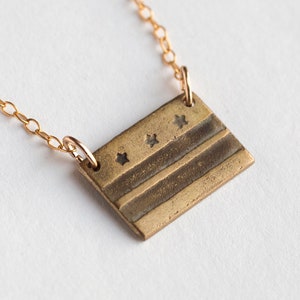 brass washington DC flag necklace, at an angle on white background