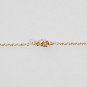 Close up of a lobster clasp on gold chain