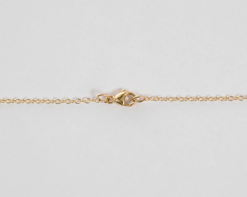 Close up of a lobster clasp on gold chain