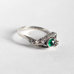 two giraffes ring in silver with rose cut emerald, laying at an angle on a white background