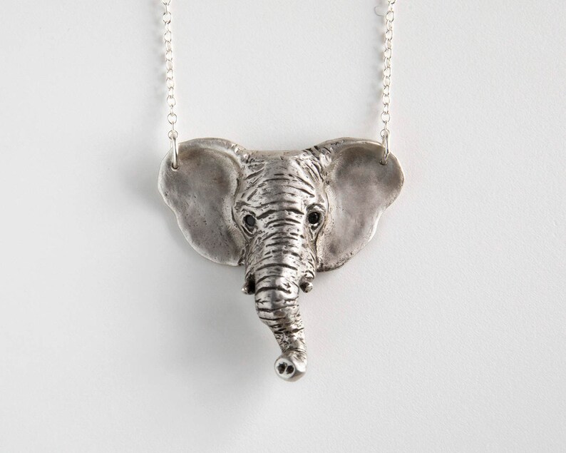 sterling silver elephant head pendant with black spinel eyes on white background