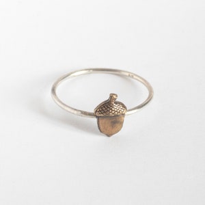 acorn ring on thin silver band, on a white background
