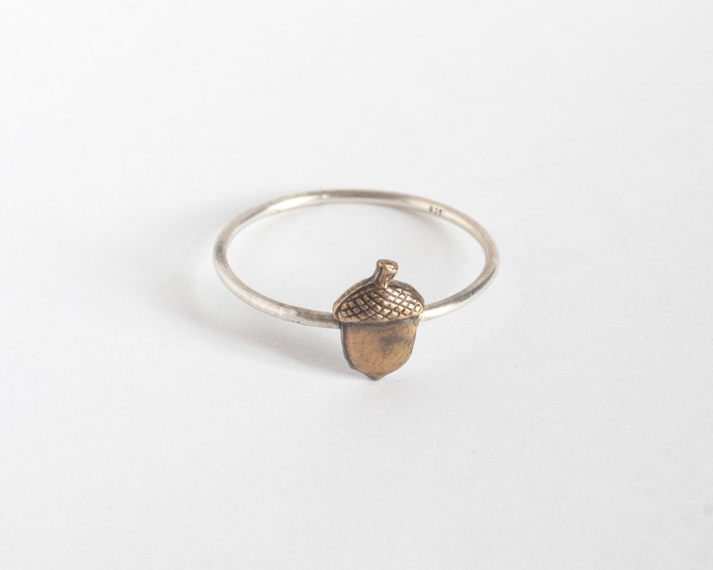 acorn ring on thin silver band, on a white background